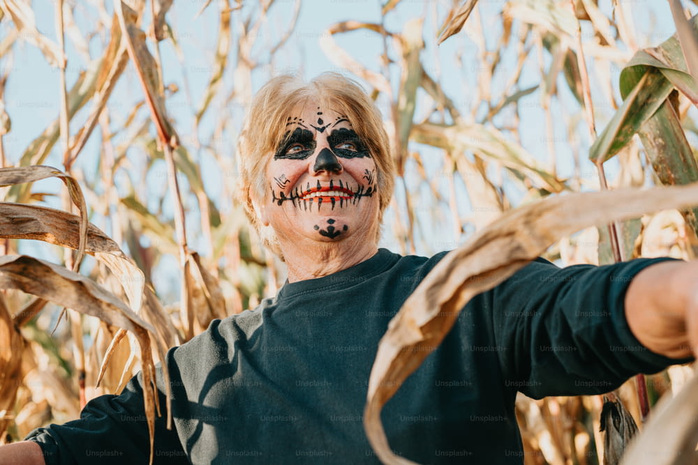 a man with a painted face standing in a field of corn