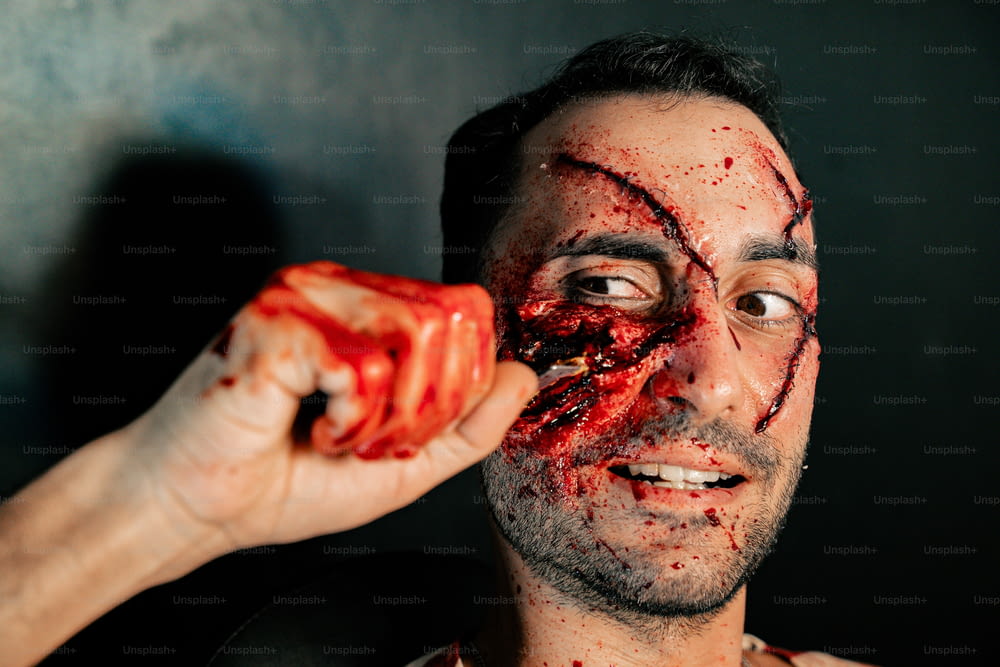 a man with a bloody face holding a piece of food