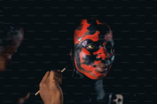 a man with a red and black face painting