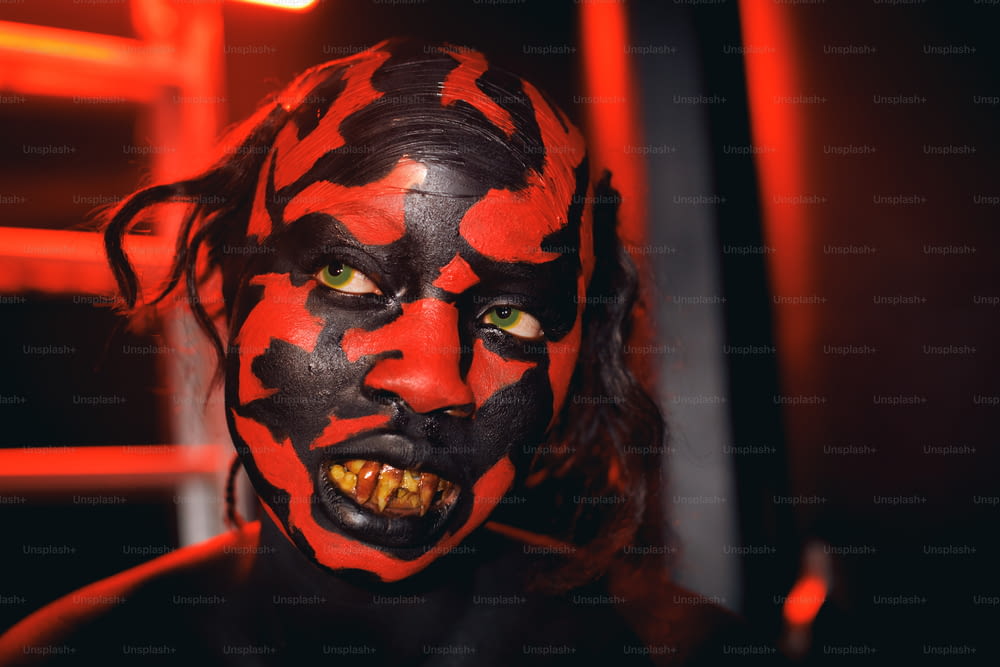 a man with a red and black face paint