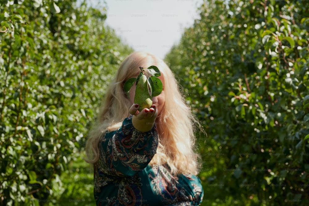 Una mujer sosteniendo una manzana verde en su cara
