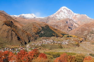 a view of a village in a valley with mountains in the background