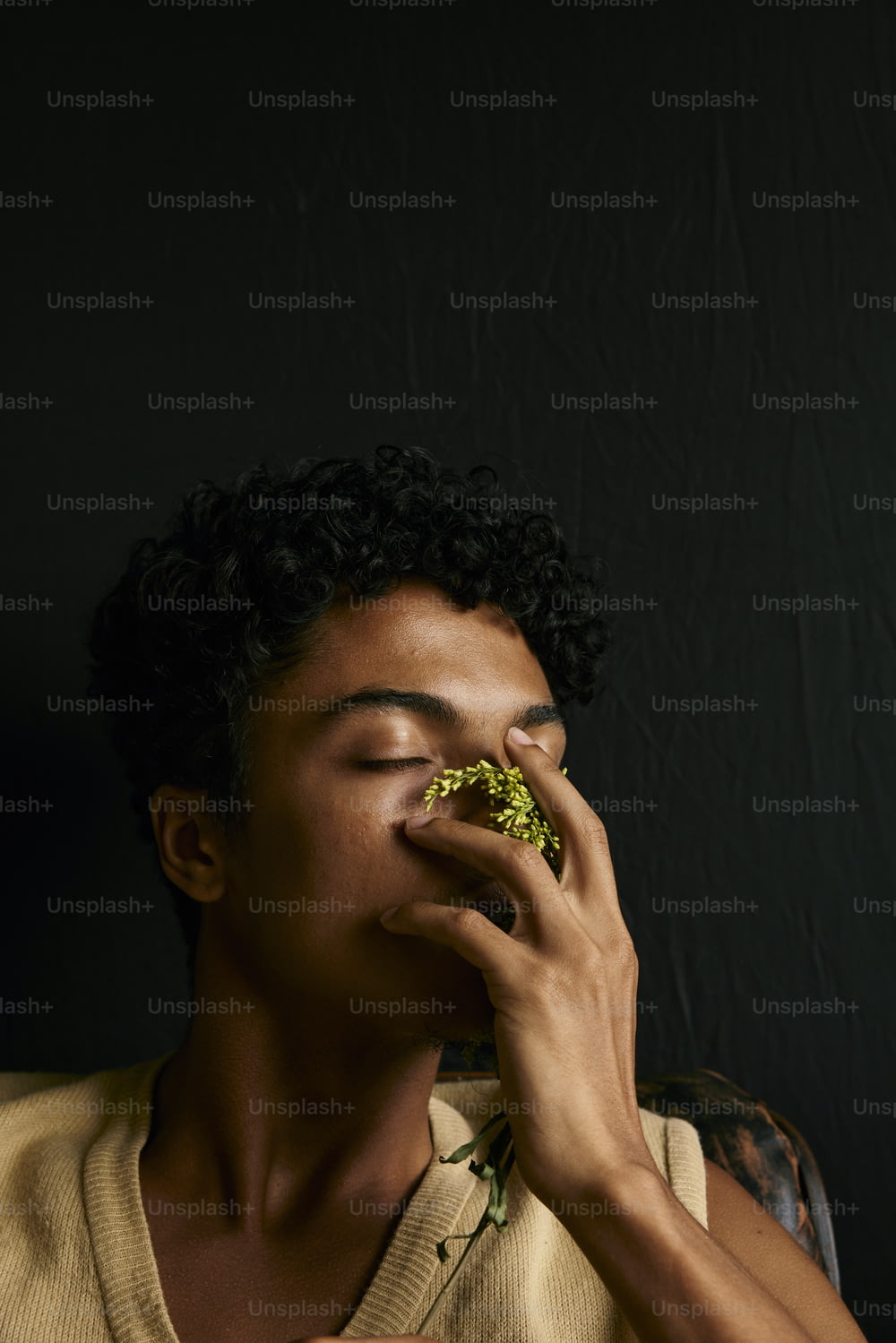 Un hombre comiendo un trozo de brócoli con los ojos cerrados