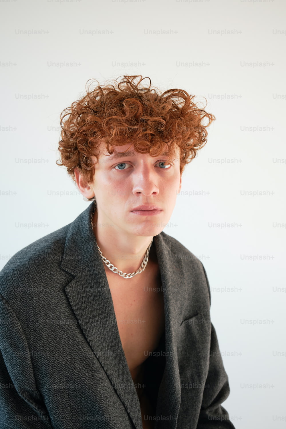 a woman with curly red hair wearing a suit