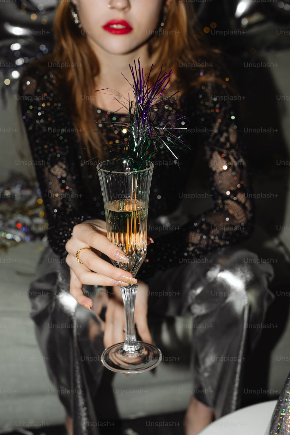 a woman sitting on a couch holding a wine glass