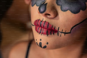 a woman's face painted with black and red flowers