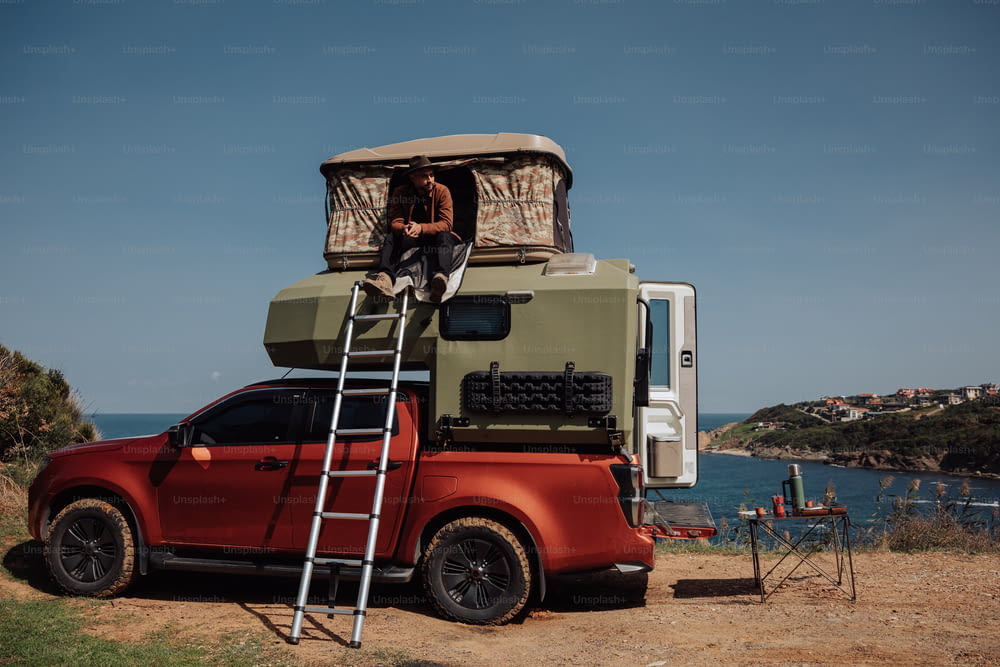 a man standing on a ladder next to a truck