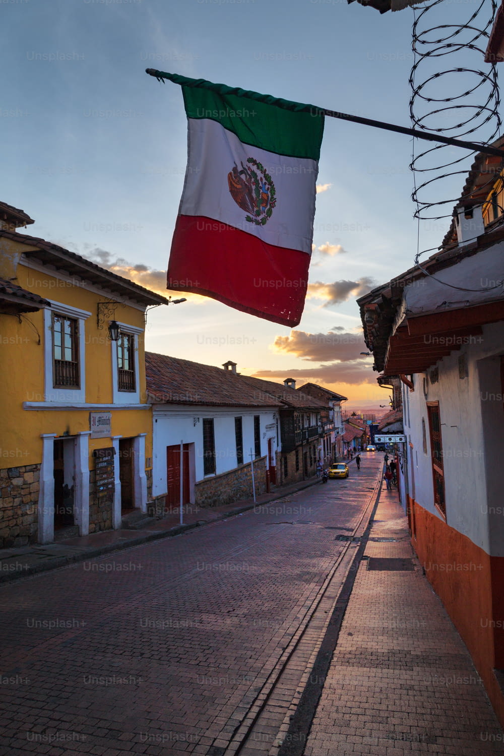 The Mexican flag over a cobblestone street in the Candelaria neighborhood of Bogota, Colombia