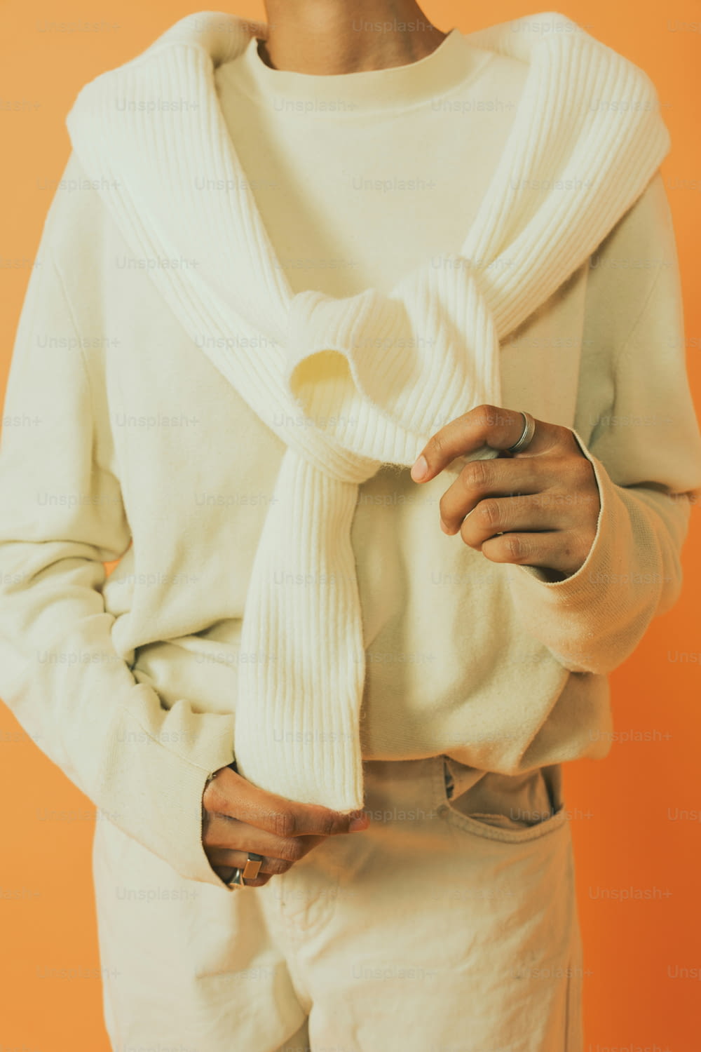 a woman wearing a white sweater and a white scarf