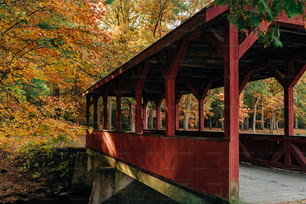 a red covered covered bridge in a park