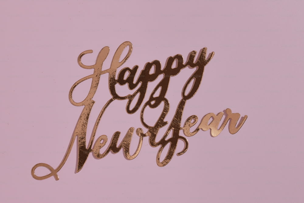 a happy new year cake topper on a pink background