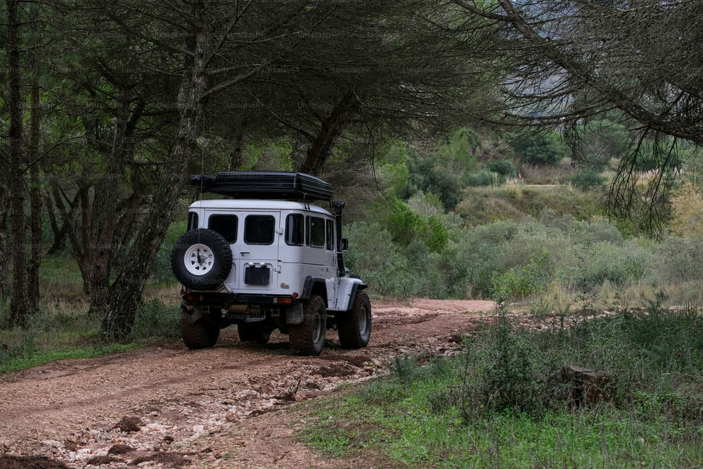 a white jeep driving down a dirt road