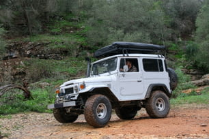 a white jeep driving down a dirt road