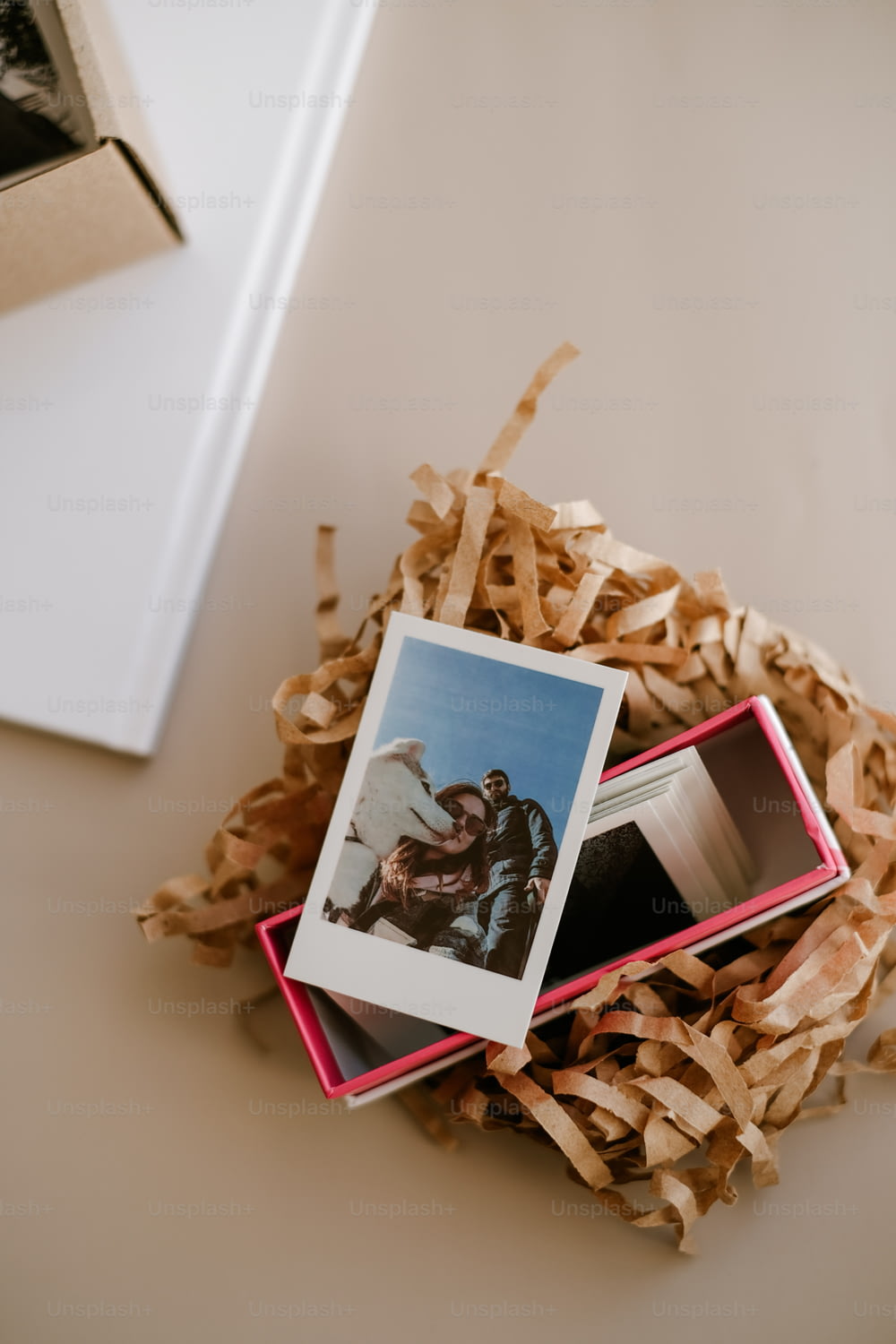 Un paio di foto polaroid sedute in cima a una catasta di legna sminuzzata
