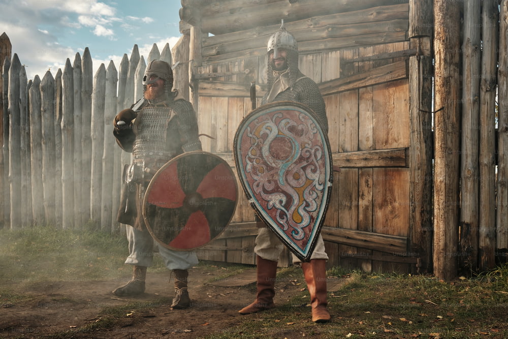 a couple of men standing next to each other holding shields