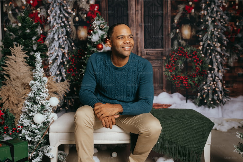 a man sitting on a bench in front of a christmas tree