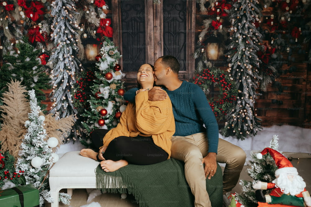 a man and woman sitting on a bench in front of christmas trees