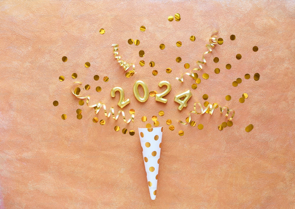 a white cone with gold confetti on top of it