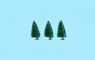 青い背景に3つの小さなクリスマスツリー