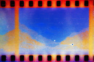 una striscia di pellicola con un cielo blu e montagne sullo sfondo