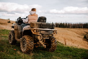 a woman riding on the back of an atv