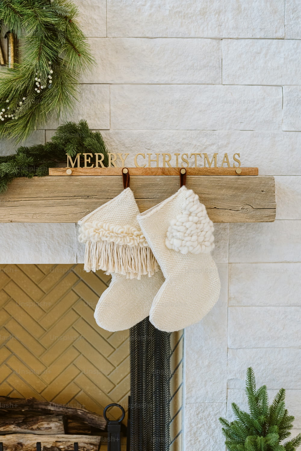 a fireplace with stockings and a merry christmas sign