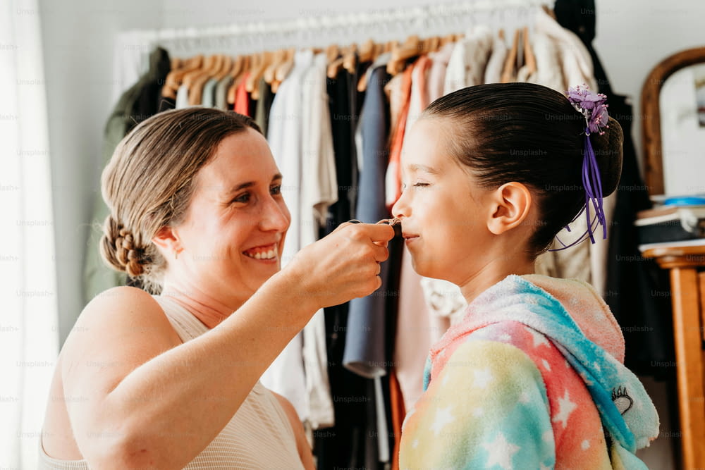 a woman is helping another woman get ready for her wedding