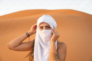 砂漠で白い頭を覆う女性