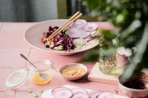a pink table topped with plates of food
