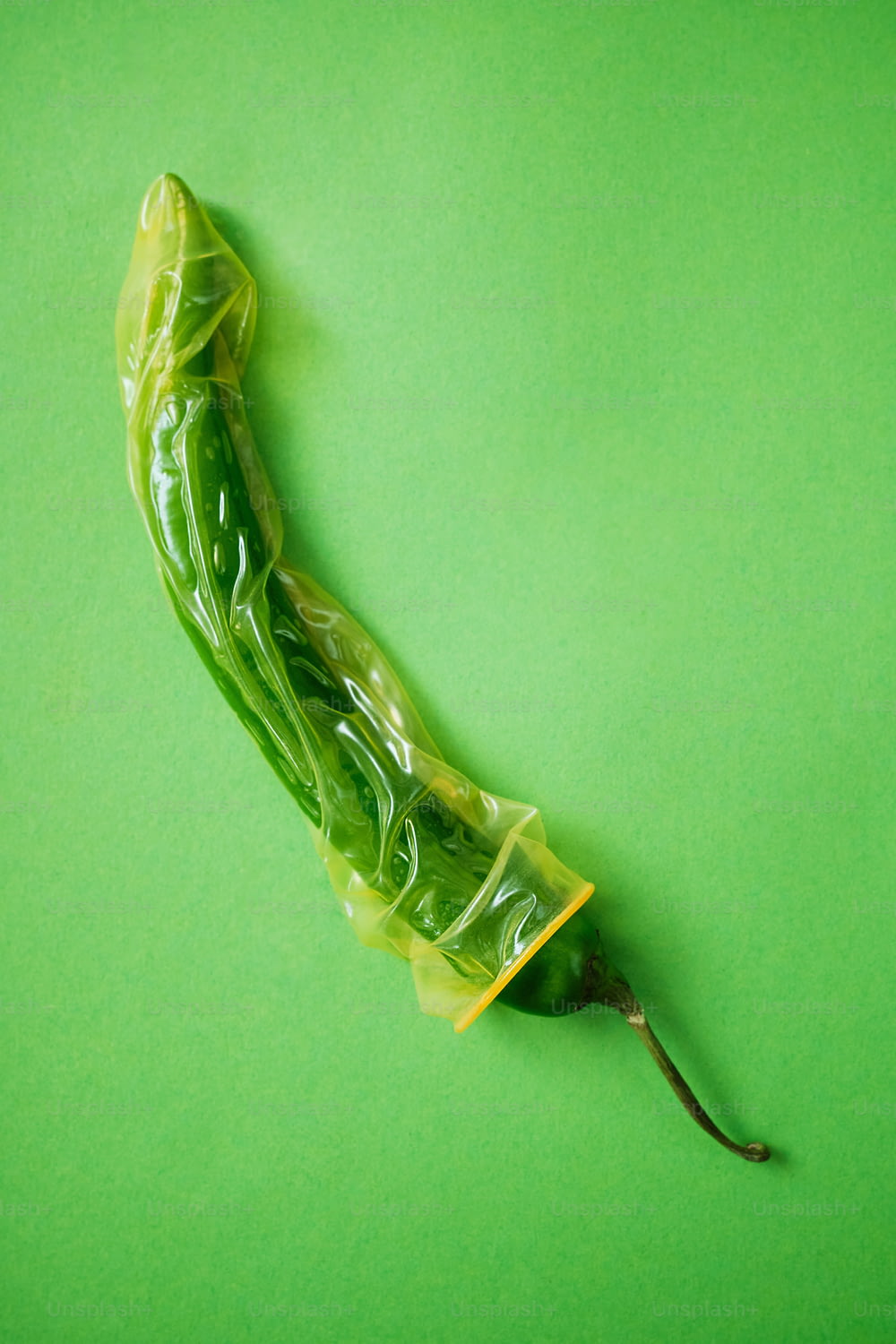una verdura verde avvolta in plastica su sfondo verde
