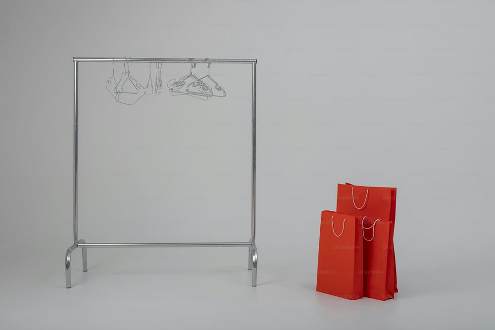 a pair of red bags sitting next to a metal rack