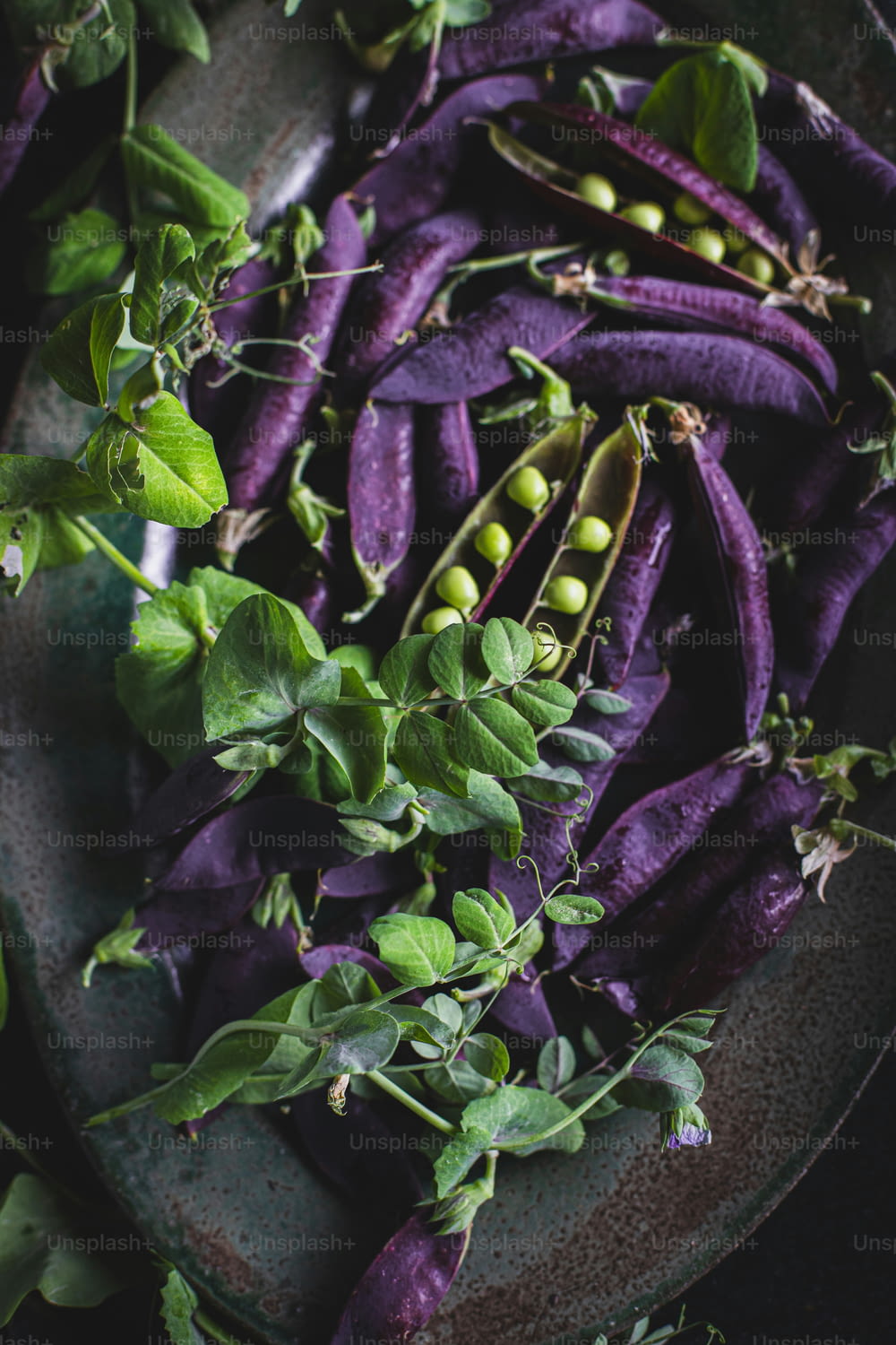 a plate of purple vegetables with green leaves