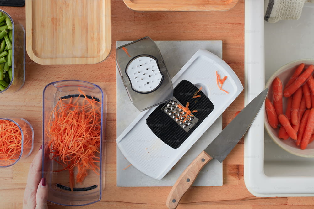 a cutting board topped with carrots and a grater
