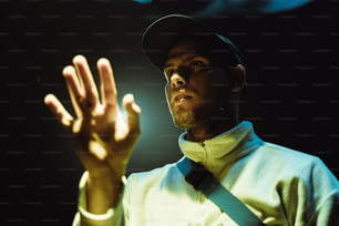um homem usando um chapéu e segurando as mãos para cima
