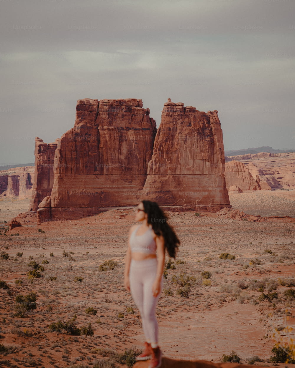 a woman in a white outfit standing in the desert