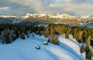 a snow covered mountain with a cabin in the foreground