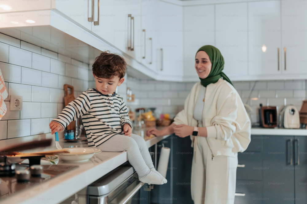 a woman standing next to a child in a kitchen