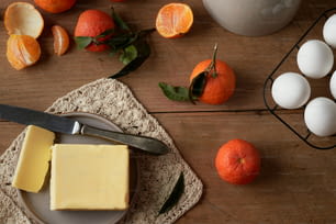 a plate with a block of butter next to some oranges