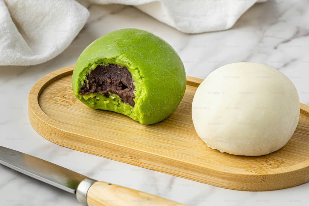 a green ball of food sitting on top of a wooden cutting board