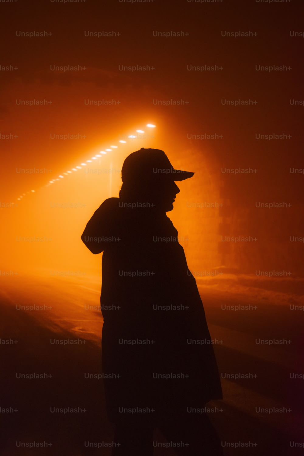 una persona parada en la niebla con un sombrero puesto