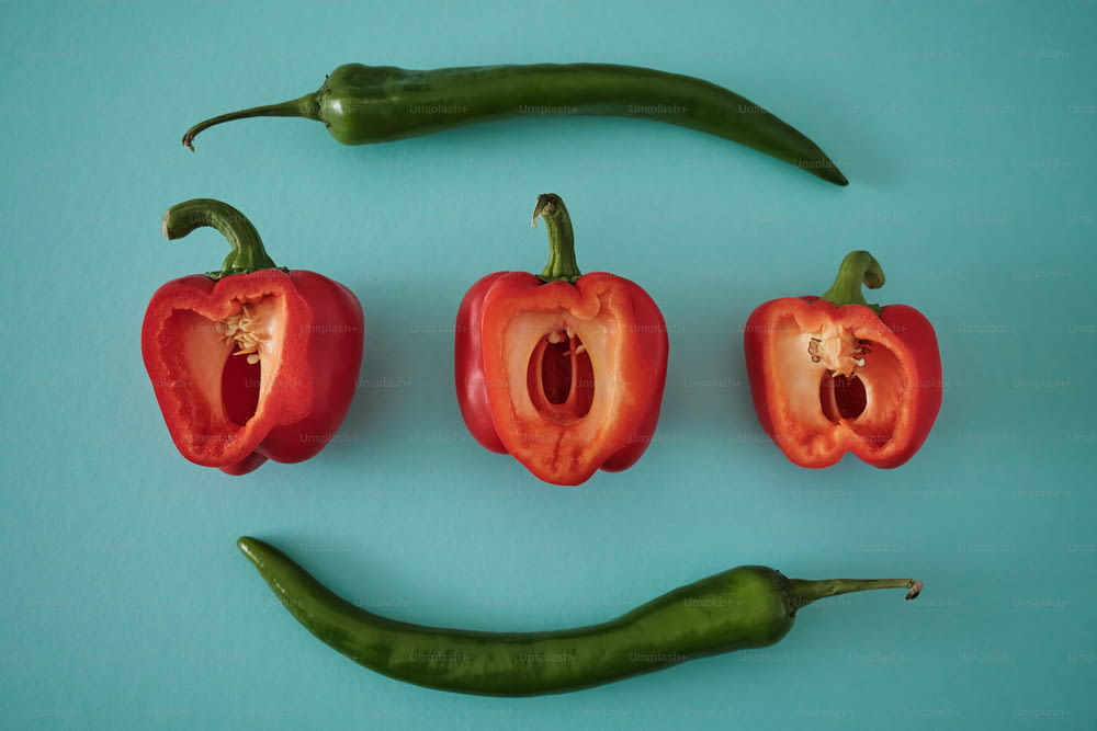 a group of red peppers with a green pepper in the middle