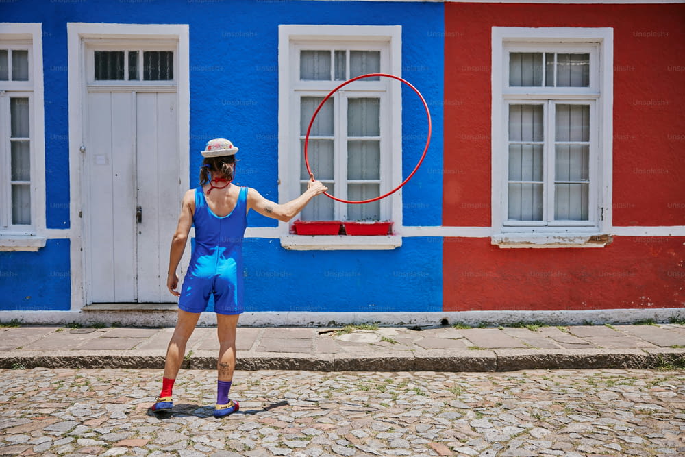 a man holding a hoop in front of a building
