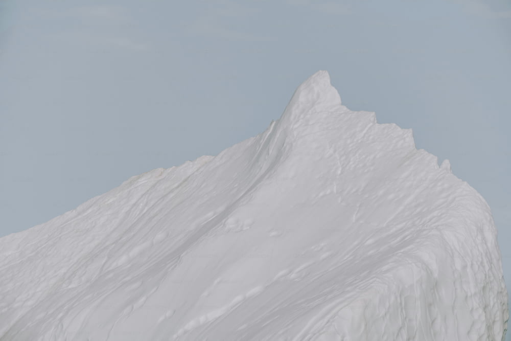 uma pessoa em um snowboard em frente a uma montanha coberta de neve