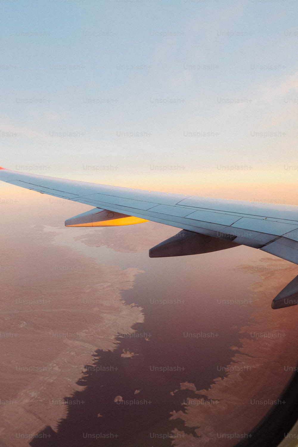 Una vista del ala de un avión mientras vuela sobre un cuerpo de agua