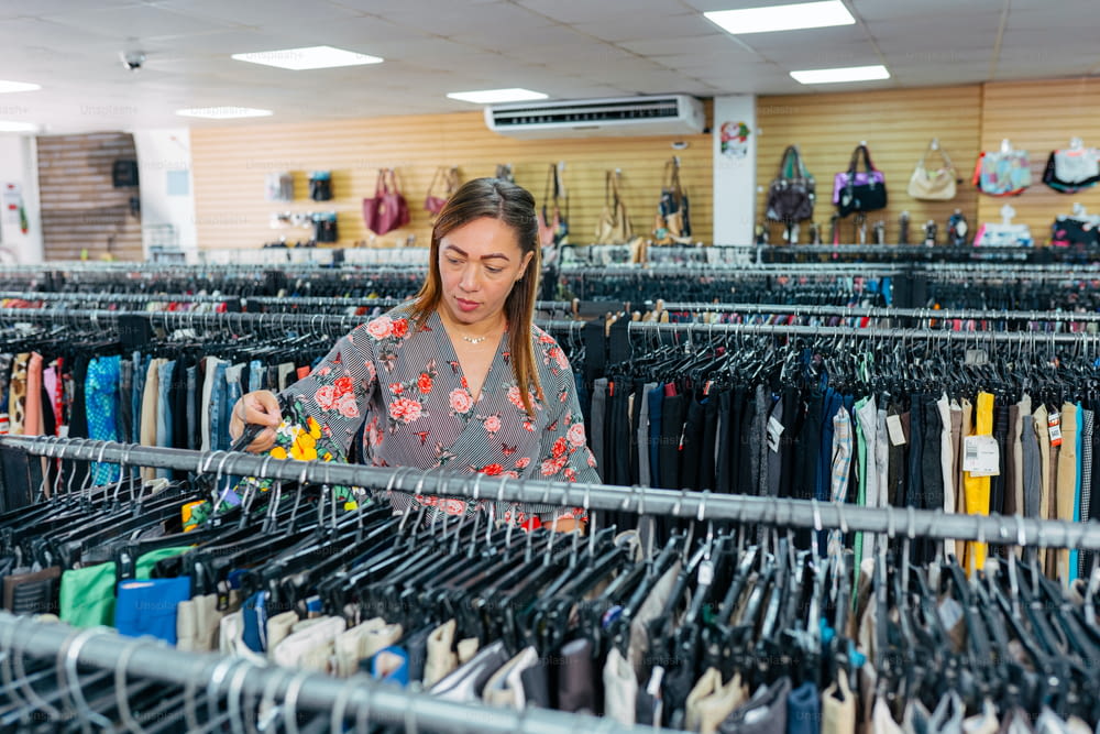 a woman looking through a rack of clothes