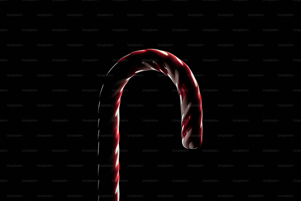 a candy cane is lit up in the dark