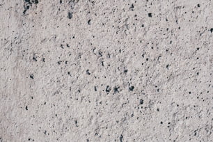 a close up of a cement surface with black dots