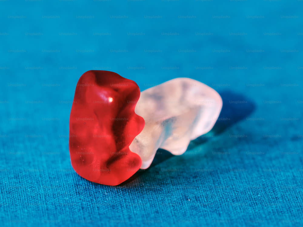 eine rot-weiße Zahnbürste, die auf einer blauen Oberfläche sitzt