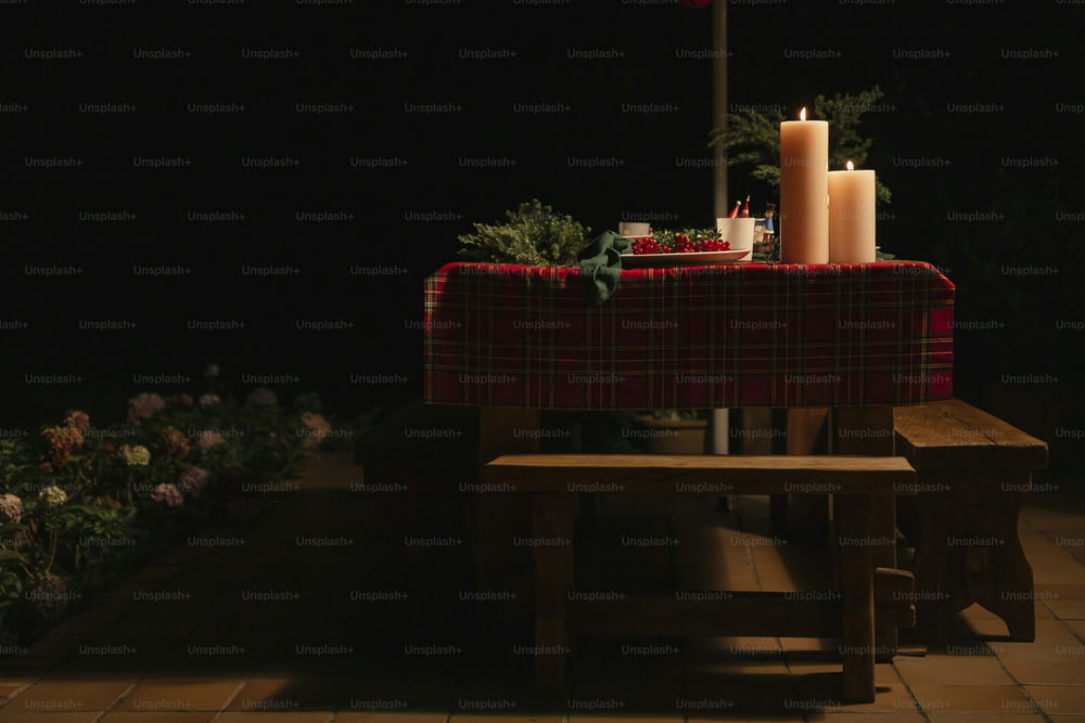 a table with a red table cloth and two candles on it