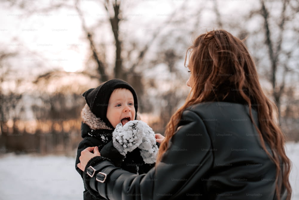 a woman holding a baby in the snow